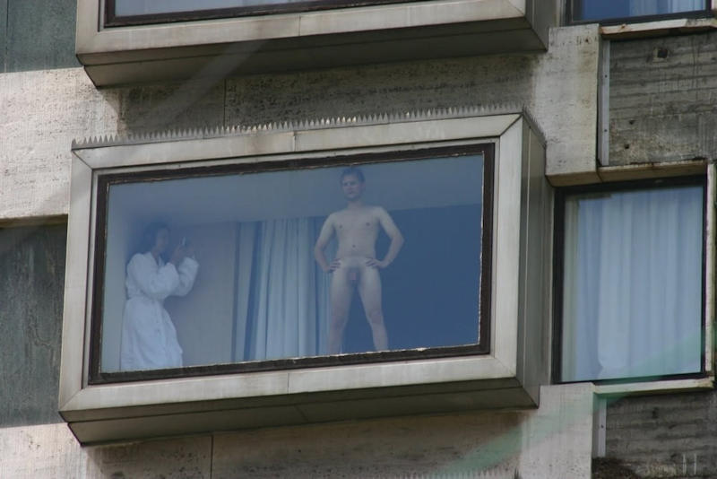 窓際で全裸姿を晒してる痴女のエロ画像の画像1枚目